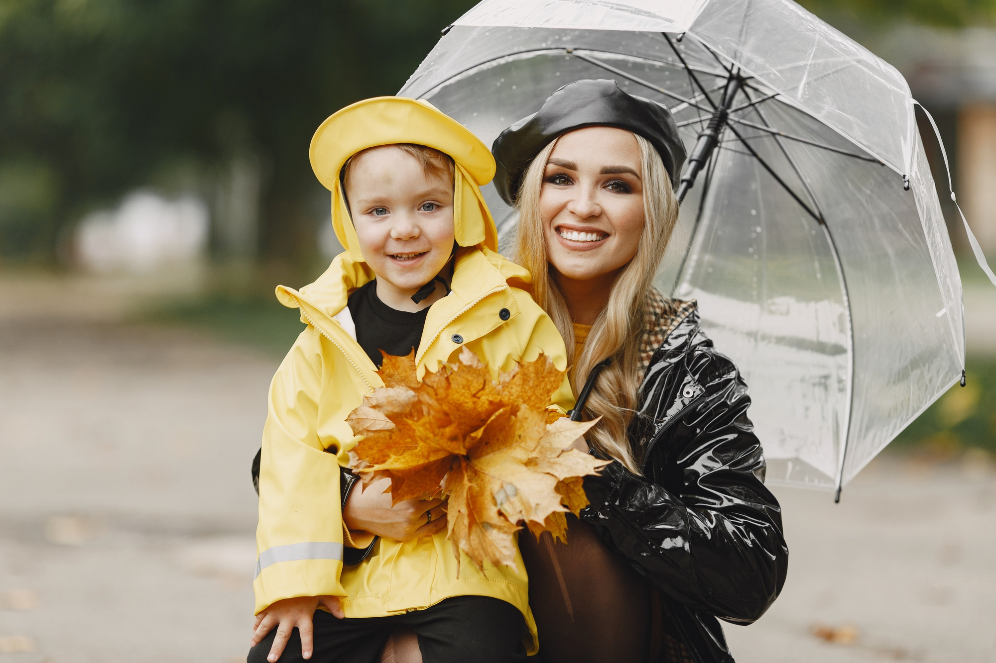 ผู้หญิงและเด็กใส่เสื้อกันฝนและกางร่ม